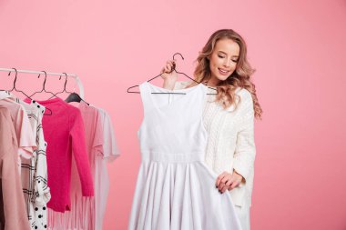 Güzel Bayan raf atölye asılı giysiler seçmek.