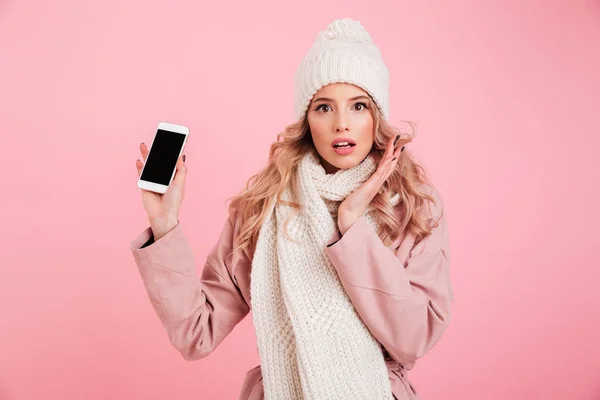 Scioccato giovane donna indossa sciarpa calda mostrando telefono — Foto Stock