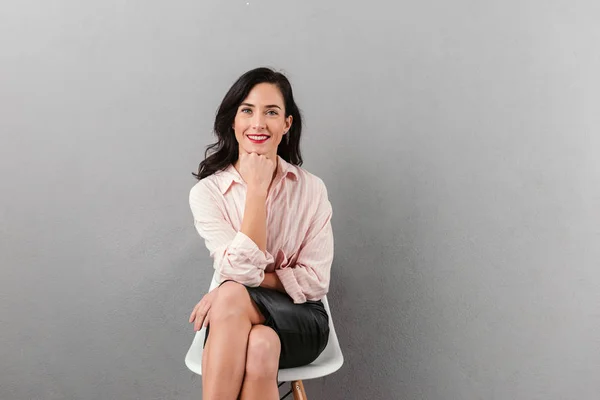 Retrato de uma mulher de negócios sorridente sentada em uma cadeira — Fotografia de Stock