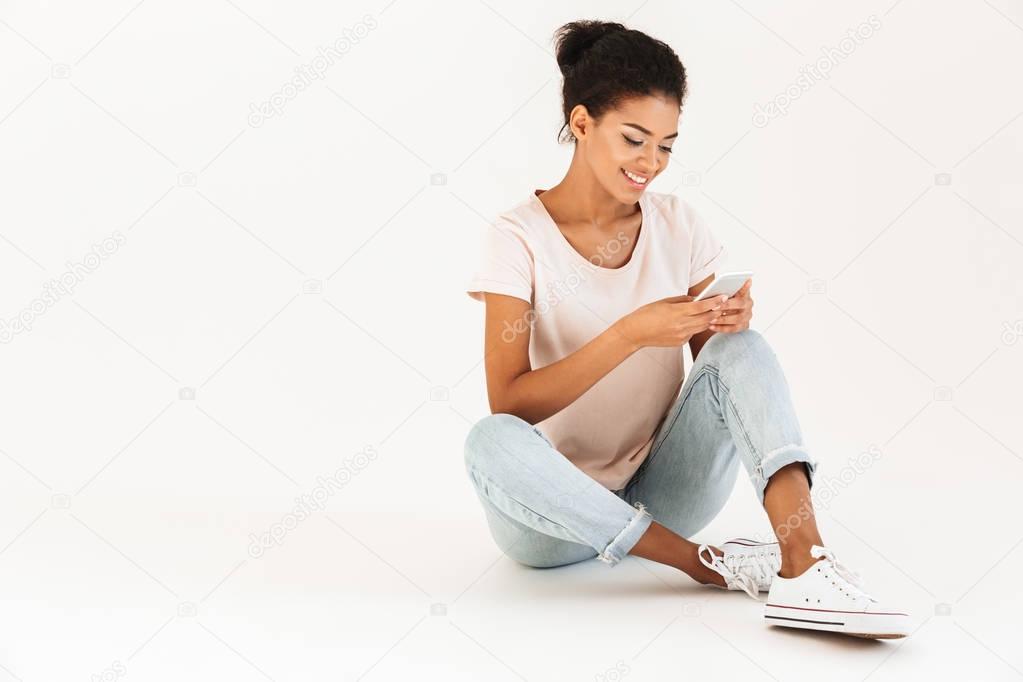 Portrait of afro american woman in casual sitting on floor with 