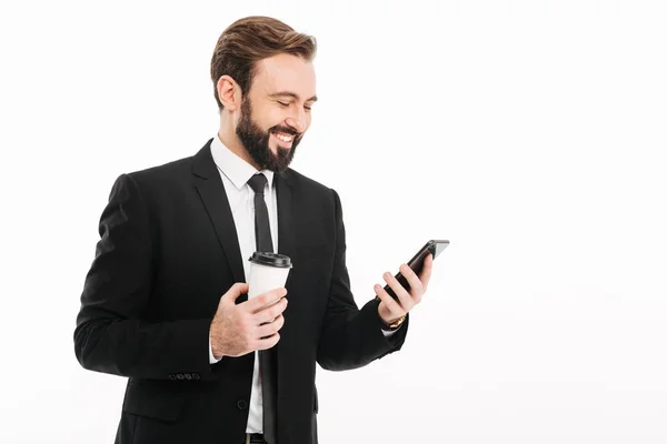 Szczęśliwy młody biznesmen za pomocą telefonu komórkowego, picia kawy. — Zdjęcie stockowe