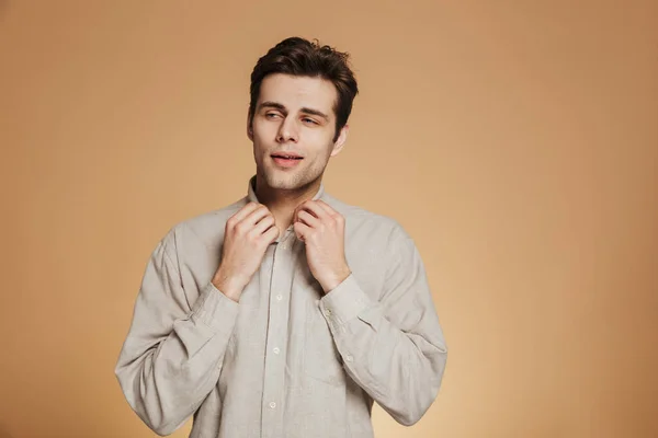 Портрет уверенного молодого человека, застегивающего рубашку — стоковое фото