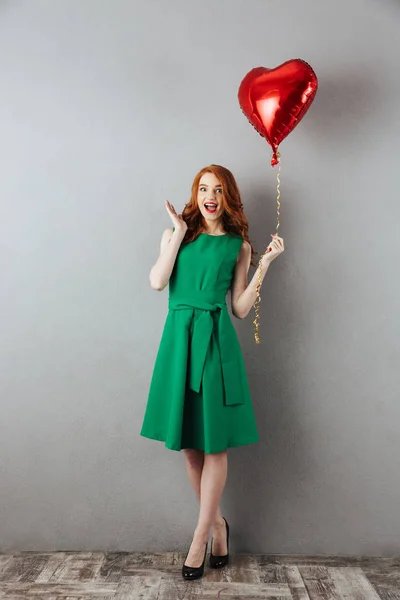 Sorprendida pelirroja joven sosteniendo globo de corazón . —  Fotos de Stock