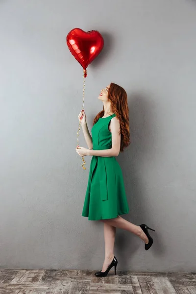 Linda pelirroja joven sosteniendo el globo del corazón . —  Fotos de Stock