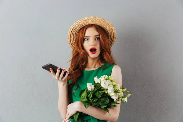 Pelirroja joven sorprendida mujer flores charlando por teléfono . — Foto de Stock