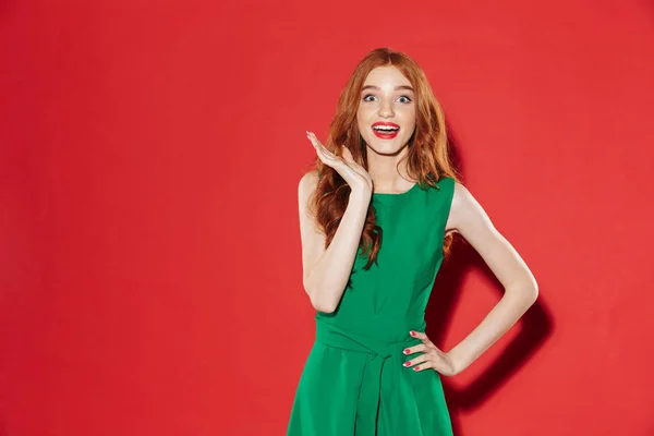 Sorpresa donna felice in abito verde con braccio sul fianco — Foto Stock