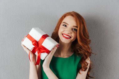 Yeşil elbise holding hediye neşeli Kızıl saçlı genç kadın