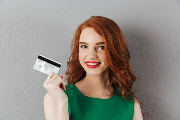 Счастливая рыжая молодая женщина с кредиткой . — стоковое фото