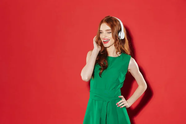 Pelirroja joven feliz chica escuchando música con auriculares — Foto de Stock