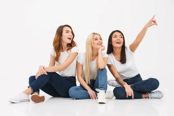 Drie jonge mooie meisjes wijzen opgewonden. — Stockfoto