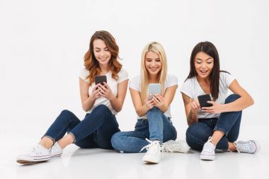 Üç genç mutlu güzel kızlar arkadaş sohbet cep telefonları tarafından.