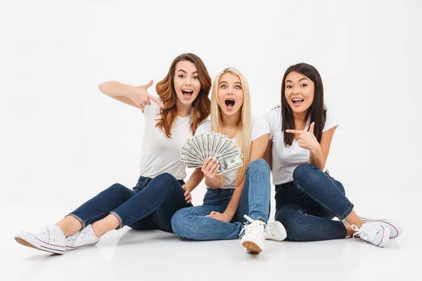 Três jovens bonitos meninas bonitas mostrando dinheiro apontando . — Fotografia de Stock