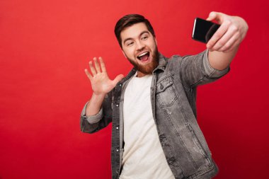 Selfie smartphone yapma ve kameraya sallayarak mutlu adam