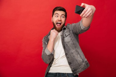 Mutlu çığlık atan adam smartphone ile açık ağız selfie yapma