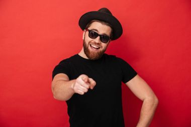 Siyah güneş gözlüğü ve şapka giyen tıraşsız neşeli adam fotoğrafı 