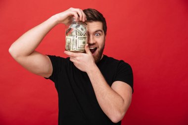 Kavanoz para dolu tutan mutlu sakallı adam