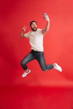 Cep telefonu kullaranarak atlama duygusal sakallı adam