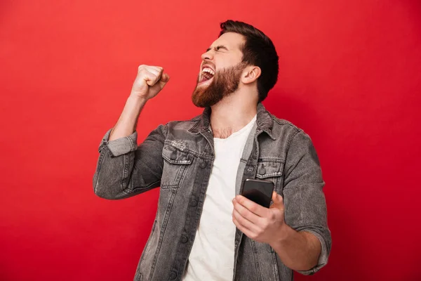 Positiv brunett man knyta näven och jubel när du håller ner — Stockfoto