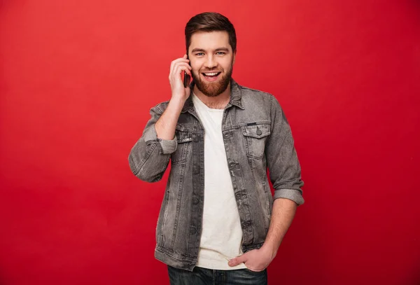 Photo of handsome brunette man holding cell phone while having m — Stock Photo, Image