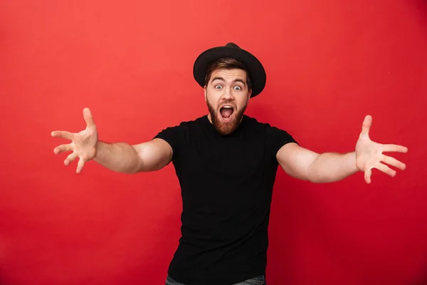 Φωτογραφία: αστεία ευτυχισμένος άνθρωπος φορώντας μαύρο t-shirt και καπέλο συναισθηματική — Φωτογραφία Αρχείου