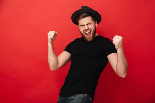 Portret van extatische Kaukasische macho man in zwarte outfit rejoici — Stockfoto