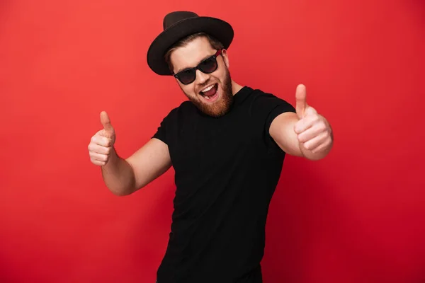 Görüntü siyah güneş gözlüğü ve şapka SMIL giyen heyecanlı genç adam — Stok fotoğraf