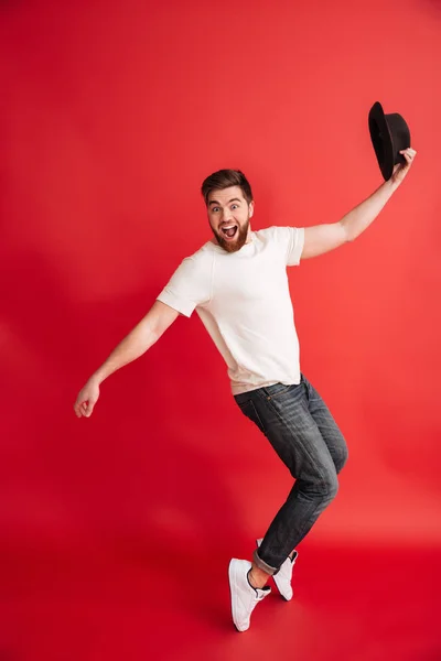Excited bearded man dancing wearing hat. Looking camera — Stock Photo, Image