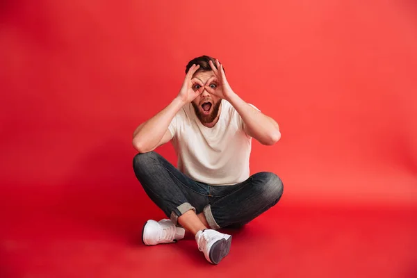 Emotionele bebaarde man zittend op de vloer veel plezier. — Stockfoto