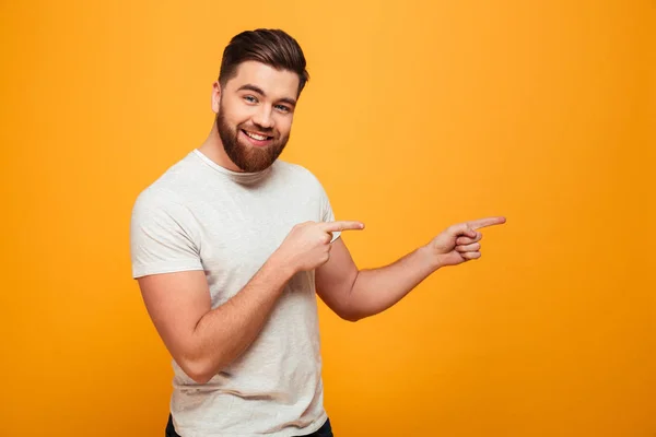 Retrato de un hombre barbudo sonriente señalando — Foto de Stock