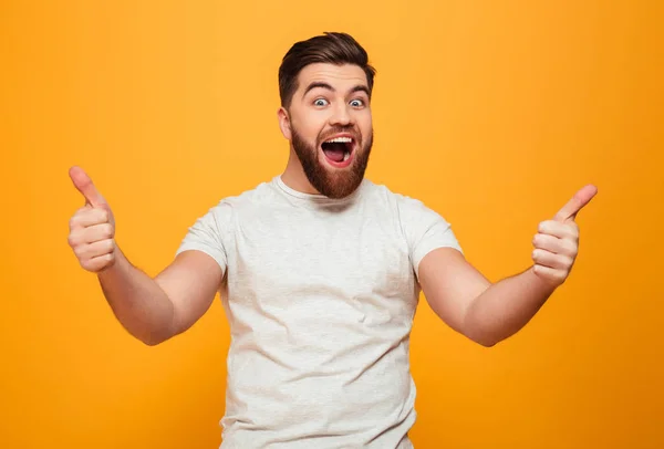 Retrato de un hombre barbudo feliz mostrando los pulgares hacia arriba — Foto de Stock