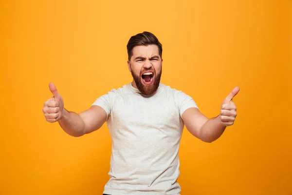 Retrato de un hombre barbudo excitado mostrando pulgares hacia arriba — Foto de Stock