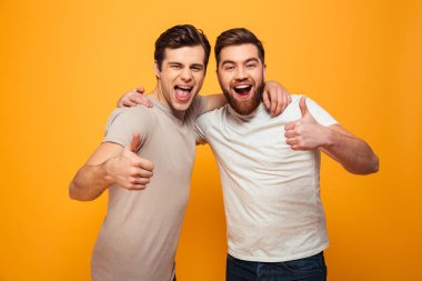 Başparmak gösterilen iki mutlu genç adam portresi