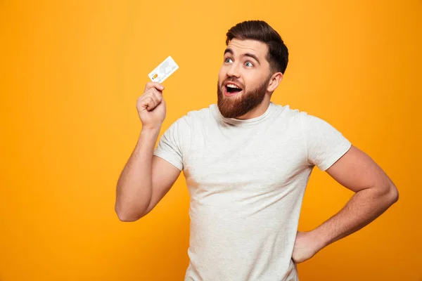Kredi kartı tutan mutlu sakallı bir adam portresi — Stok fotoğraf
