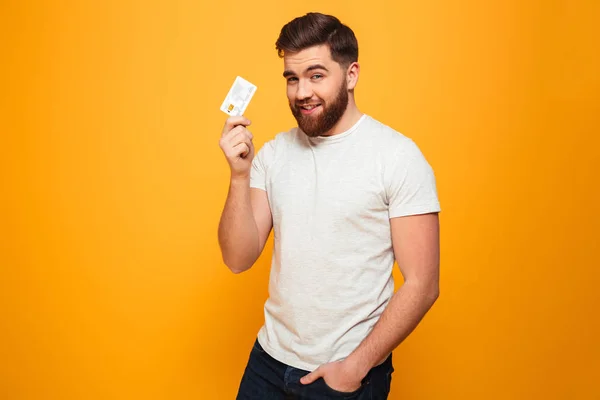 Portrait of a smiling bearded man showing credit card — Stock Photo, Image