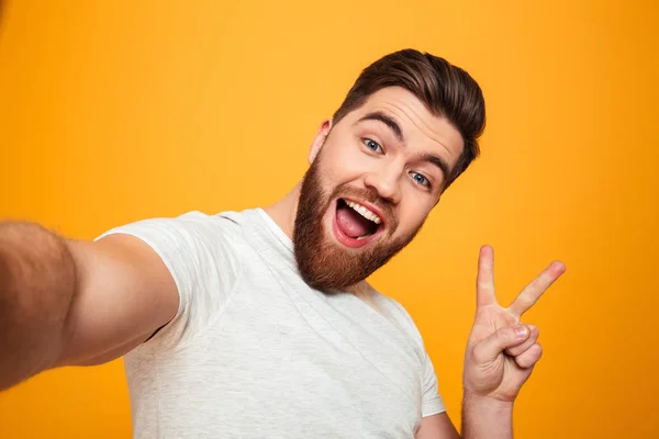 Portrét veselý vousatý muž ukazuje míru gesto — Stock fotografie