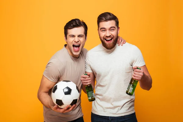 Retrato de dos jóvenes alegres sosteniendo botellas de cerveza — Foto de Stock