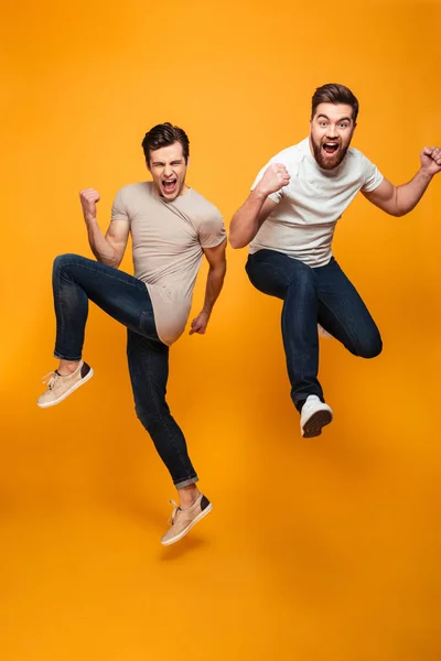 Retrato de dos jóvenes alegres saltando — Foto de Stock