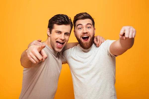 Porträt zweier glücklicher junger Männer, die mit dem Finger zeigen — Stockfoto