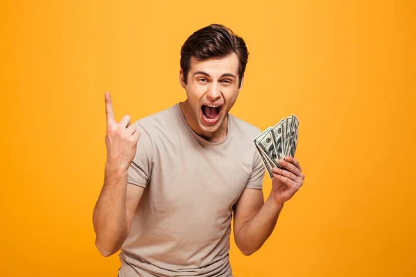 Porträtt av en upphetsad ung man hålla pengar — Stockfoto