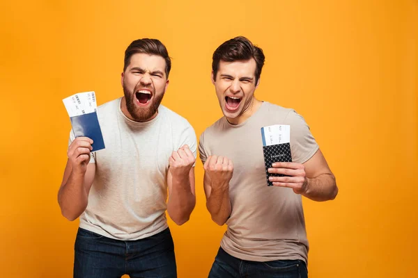 Portrait of a two happy young men holding passports — Stock Photo, Image