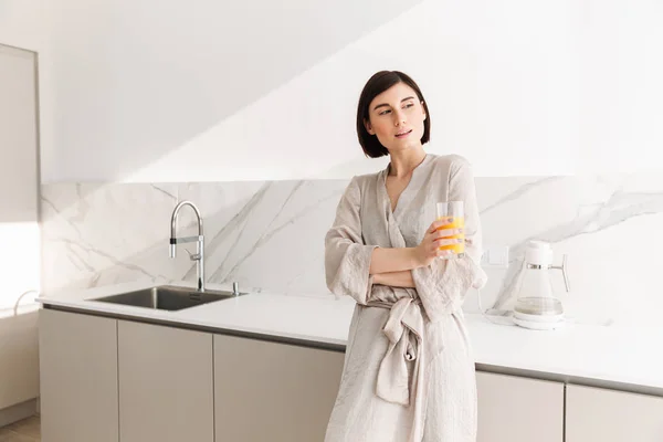 Joven mujer fascinante con pelo corto oscuro de pie en la cocina — Foto de Stock