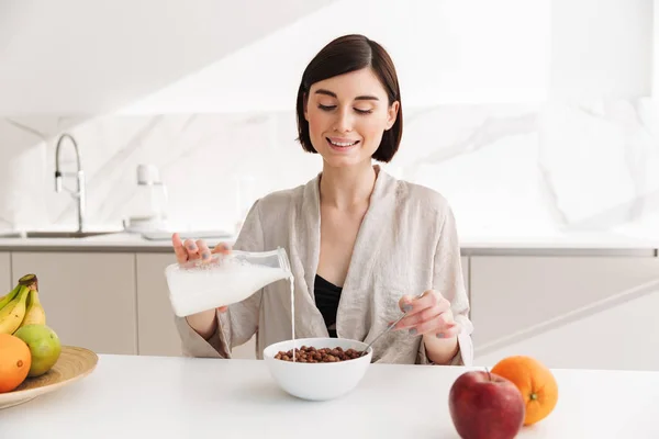 Imagen de la joven morena desayunando en la cocina en caliente — Foto de Stock