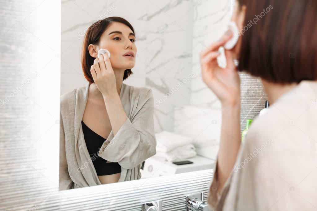 Beauty portrait of brunette woman with cosmetics on face removin