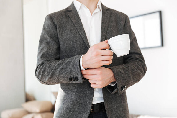 Cropped image of business man holding cup of tea