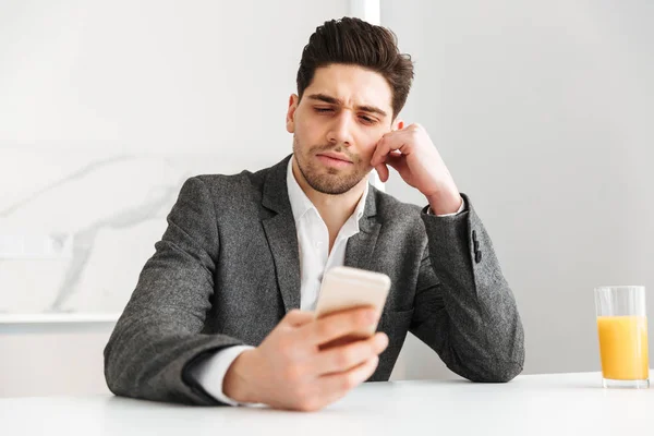 Tranquilo hombre de negocios sentado junto a la mesa en casa — Foto de Stock