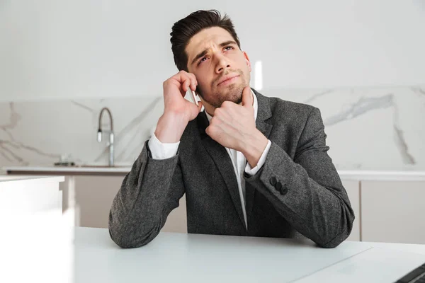 Pensive business man sitting by the table at home