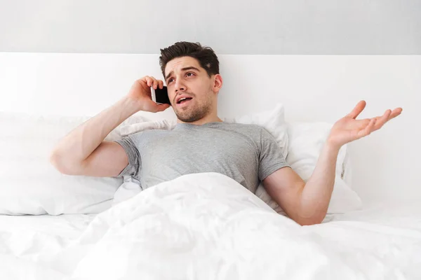 Photo de jeune homme caucasien couché seul au lit avec du linge blanc — Photo