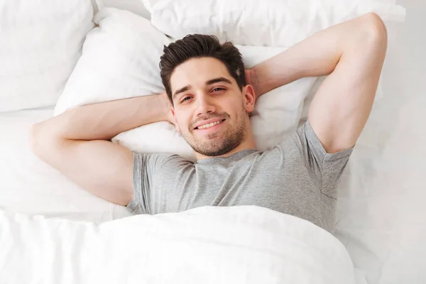 Вид зверху на брюнетку сексуальний чоловік у повсякденній футболці посміхається — стокове фото
