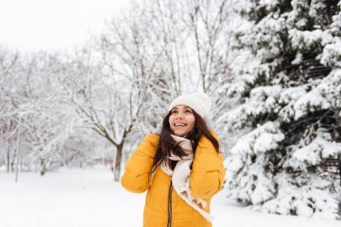 Parkta yürürken gökyüzüne bakarken gülümseyen güzel Bayan