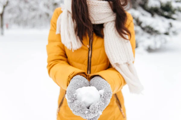 Tiro cortado de senhora segurando neve nas mãos no parque — Fotografia de Stock